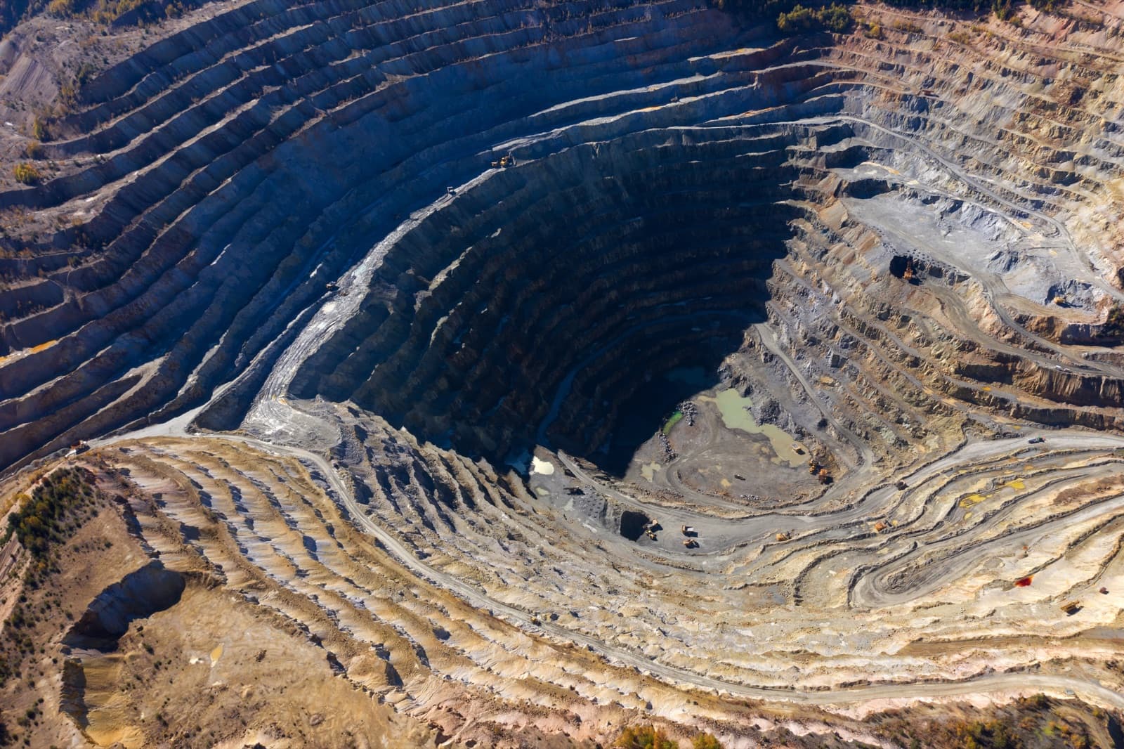 Aerial view of the terraced benches of a deep open-pit copper mine